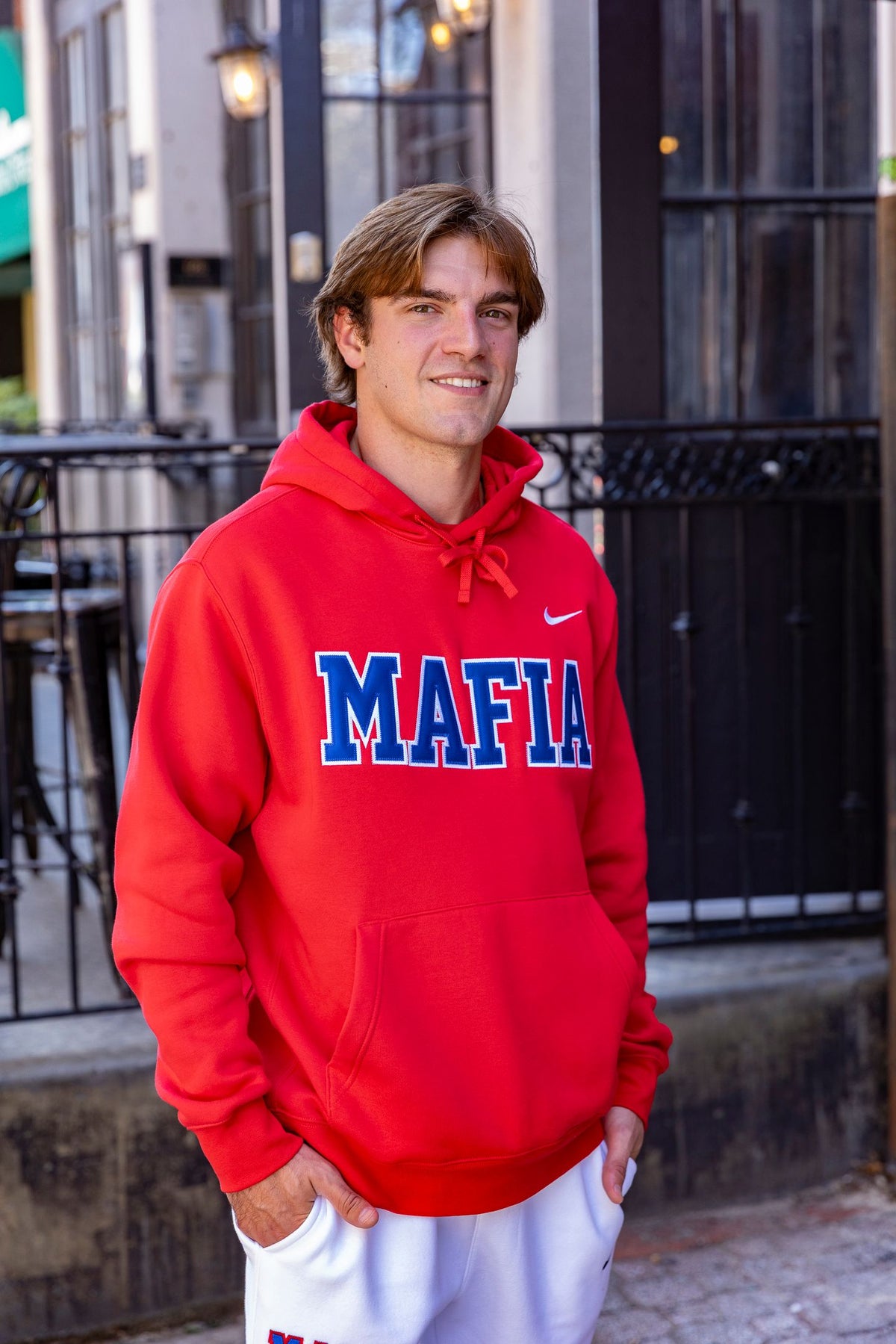 Male model wearing red MAFIA hoodie with sewn-on lettering