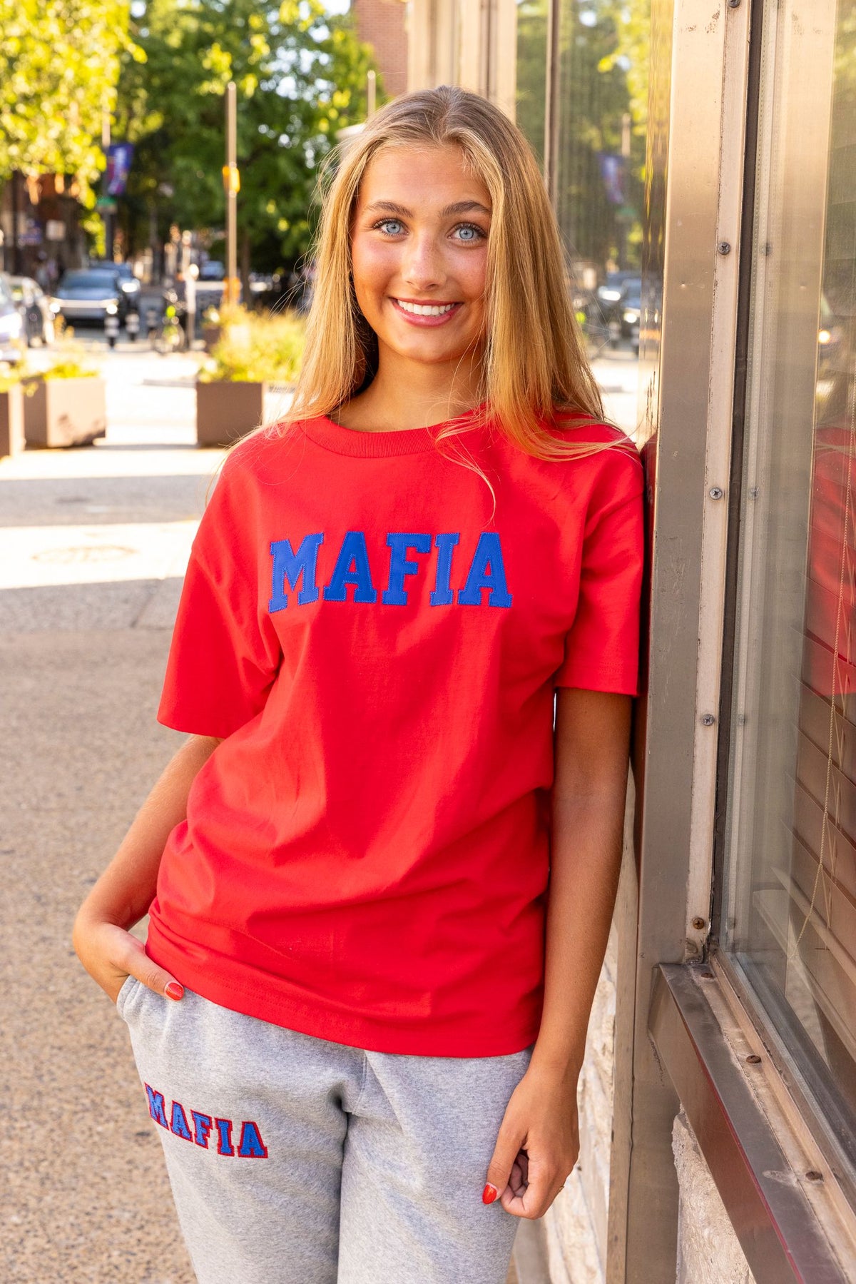 Female model wearing red MAFIA t-shirt with royal sewn-on lettering